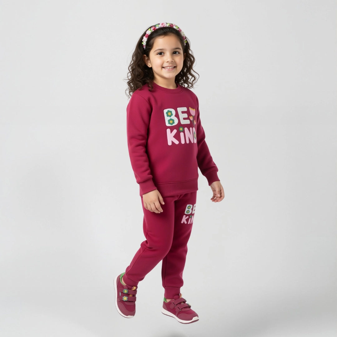 Child wearing a maroon outfit with 'Be Kind' text on a white background