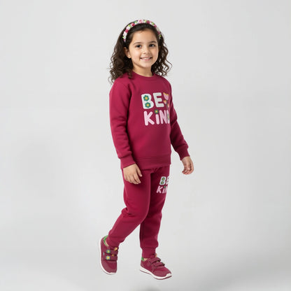 Child wearing a maroon outfit with 'Be Kind' text on a white background